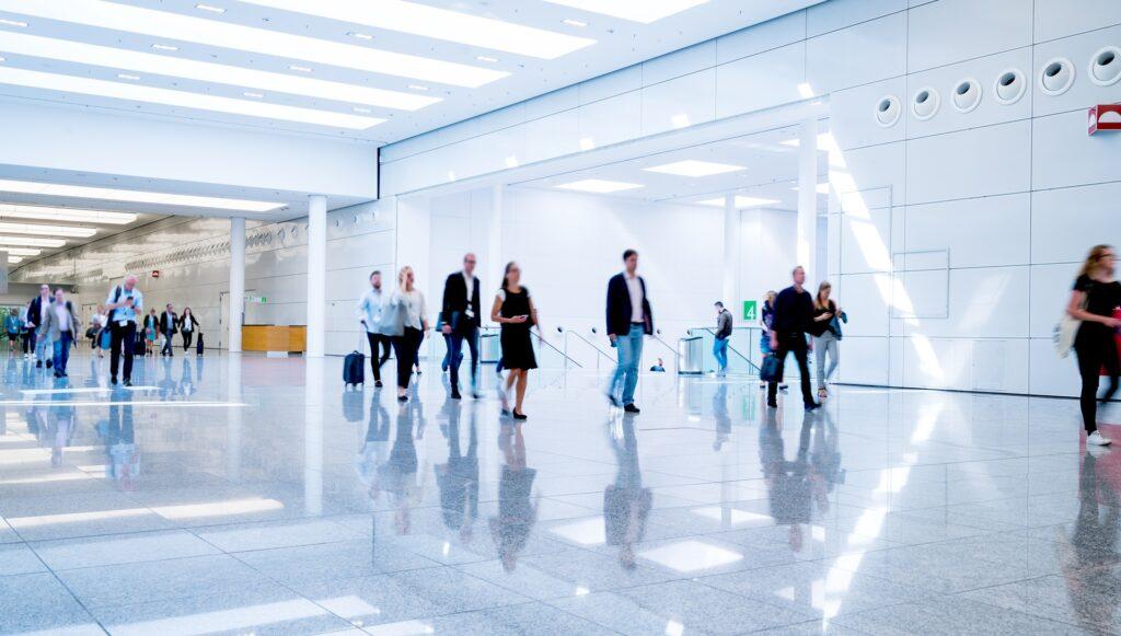 Menschen bewegen sich durch modernes Messegebäude | Vuse go