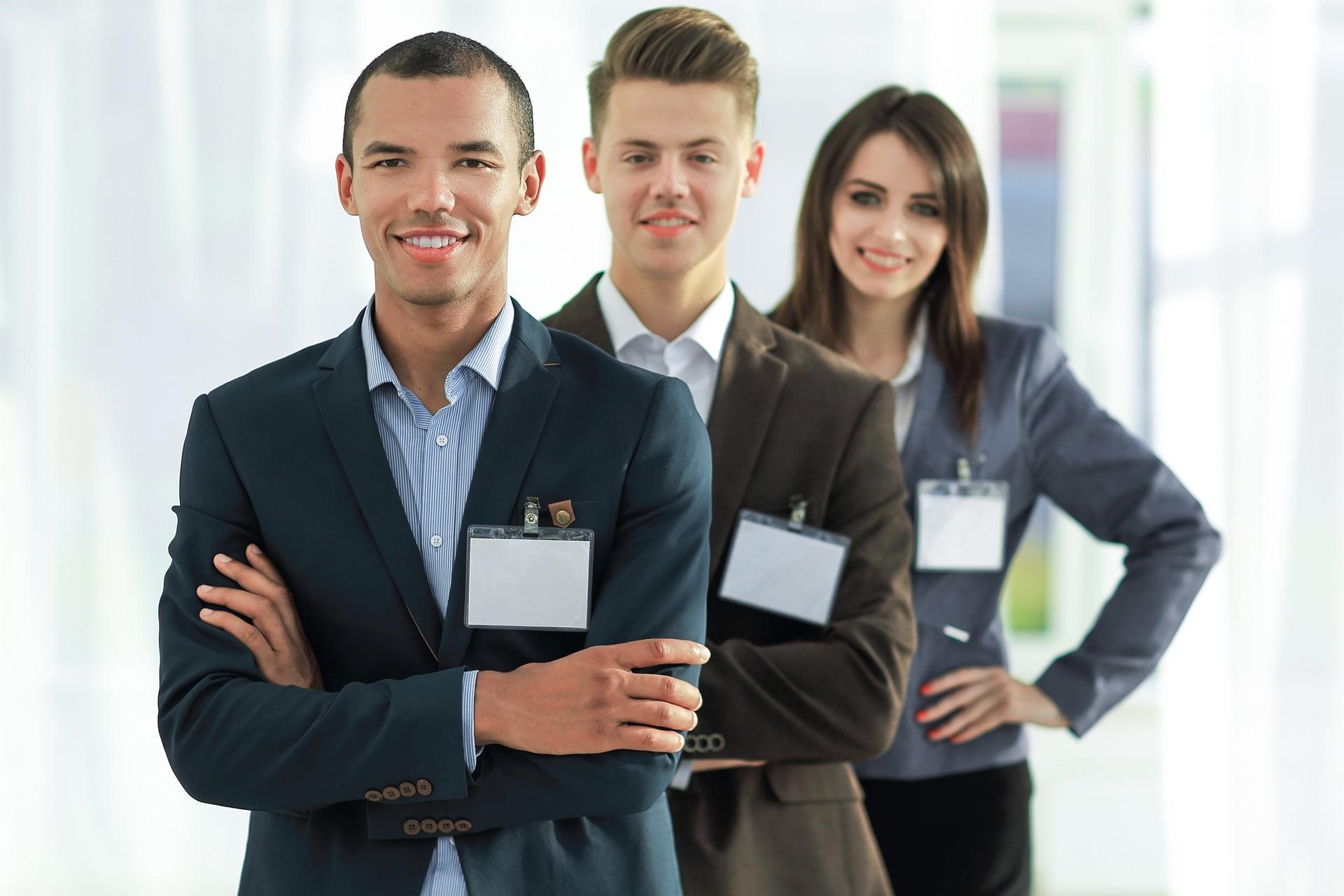 Drei lächelnde Messemitarbeiter in Businesskleidung | Vuse go